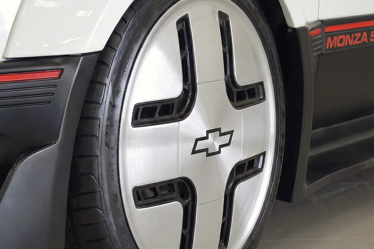 Detalhe da roda dianteira do Monza SR Concept. Roda sólida prateada com desenho em cruz e logo Chevrolet central.
