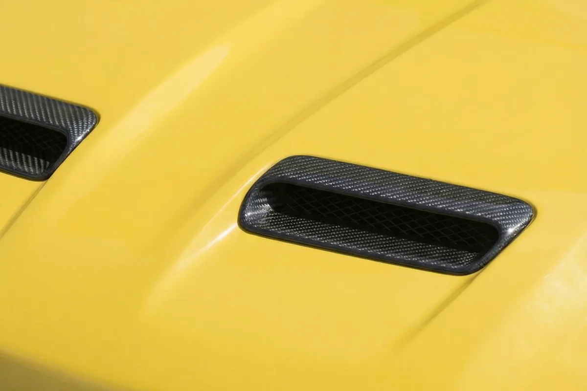 Detalhe das entradas de ar no capô amarelo do Fiat Torino 147 Concept, com acabamento em fibra de carbono.