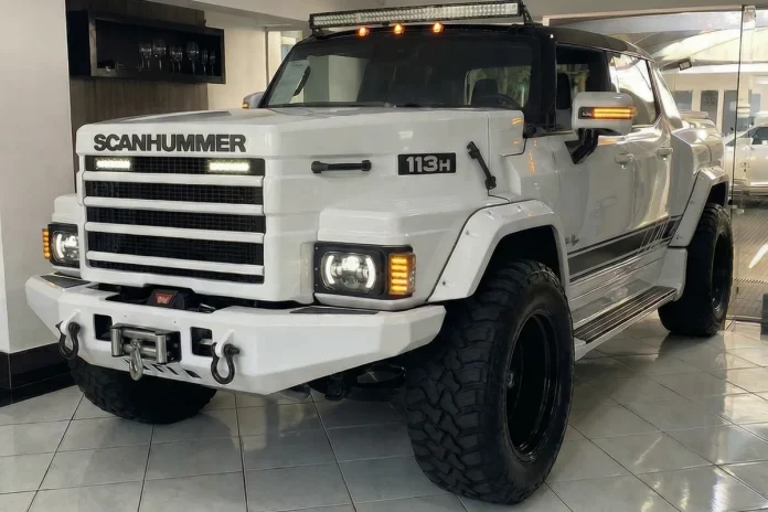 ScanHummer 113H branco visto de frente em showroom, com grade estilo Scania, faróis LED, guincho e pneus off-road