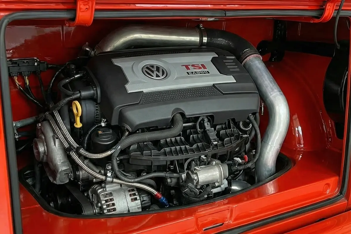 Motor Volkswagen 2.0 TSI (EA888) com turbo e tubulações personalizadas no compartimento traseiro da Kombi.